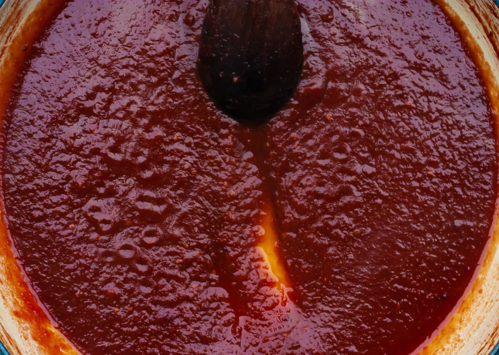 spoon dragged through tomato sauce