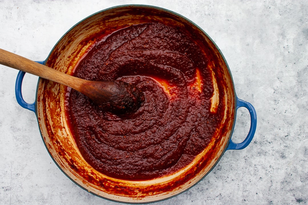 Finished, thickened sauce in a Braiser pan on a blue-grey background