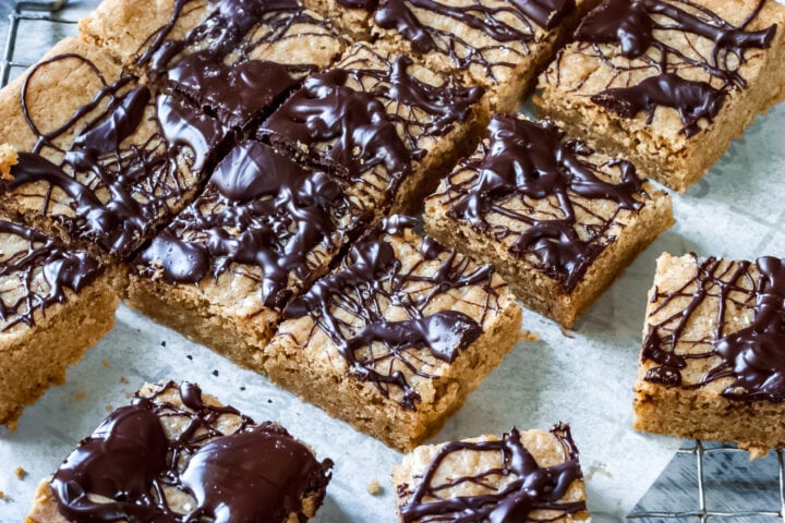 cut up salted caramel blondies on parchment paper on a baking rack