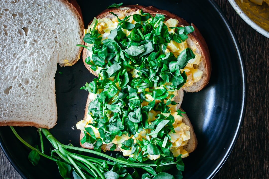 egg salad topped with watercress on a piece of bread