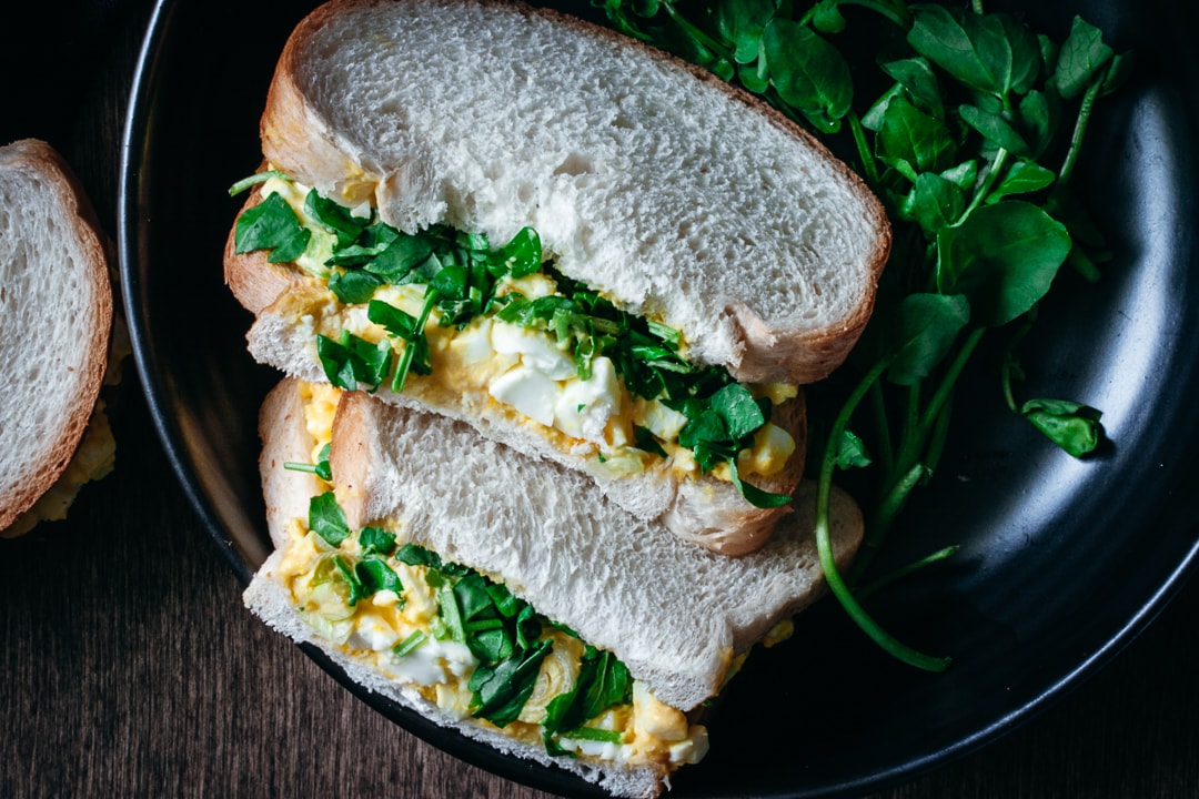 egg salad sandwich with watercress on a plate