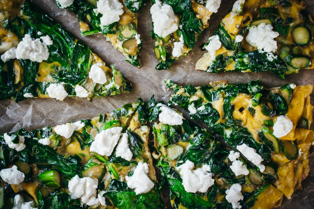 Veggie Frittata cut into wedges on a piece of parchment paper