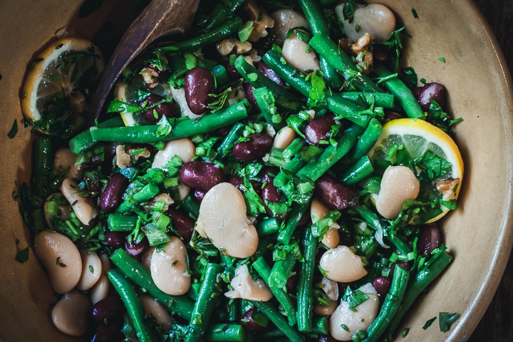 3-bean salad with lemon and dill with a wooden spoon