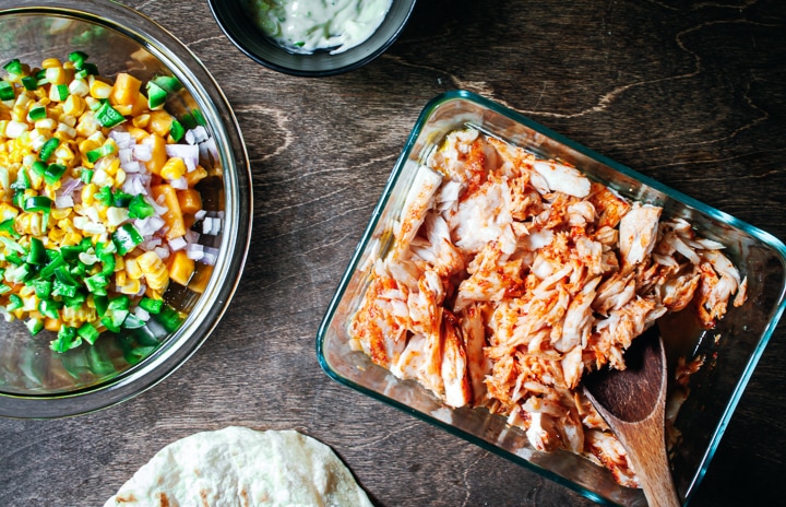 flaked fish in glass baking pan, jalapeño and peach salsa in a glass bowl, and tortillas on the side