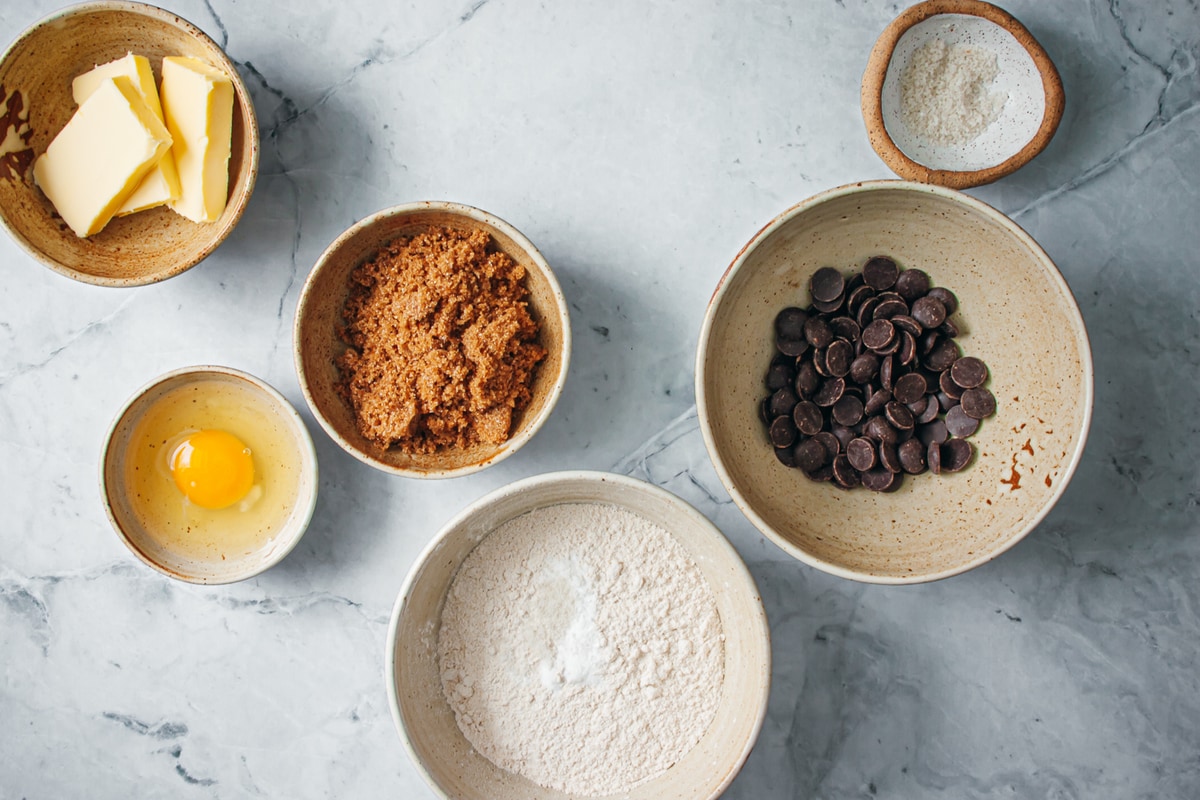 Ingredients in different size bowls for chocolate chip cookie bars