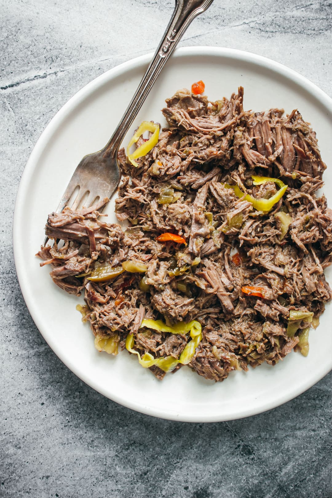 slow cooker Italian beef on a plate with a fork