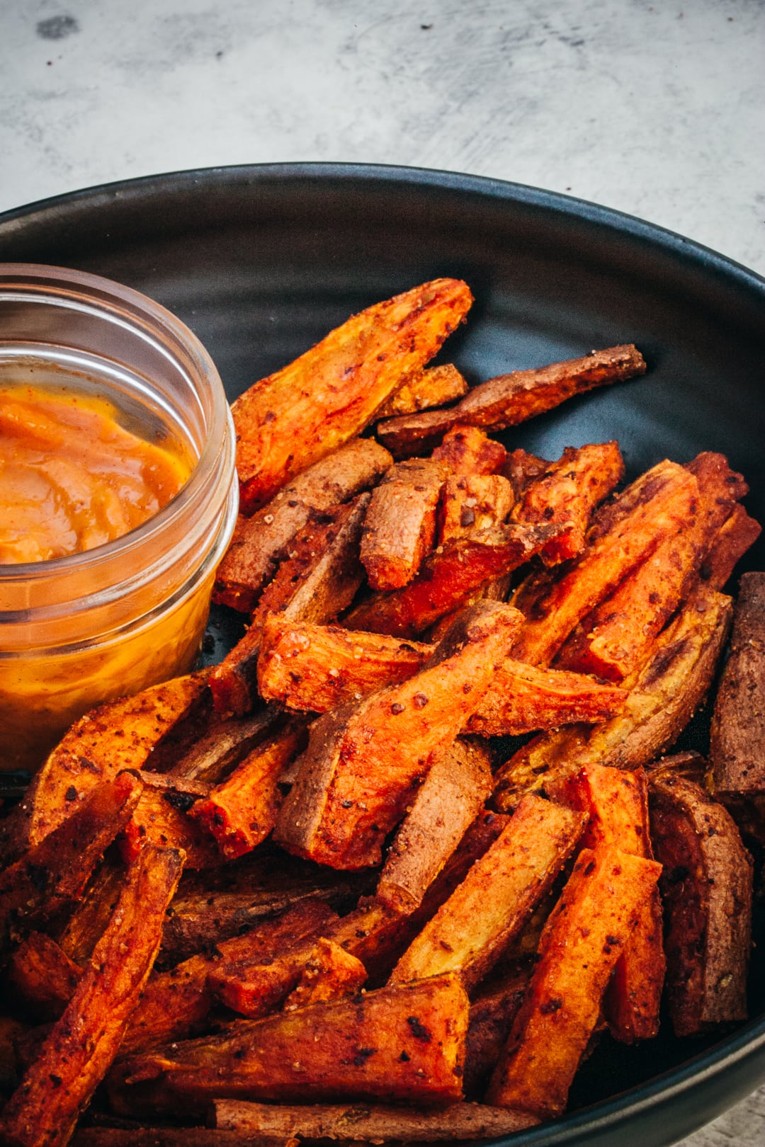 Oven-Baked Sweet Potato fries layered in a serving bowl with chipotle mayo on the side