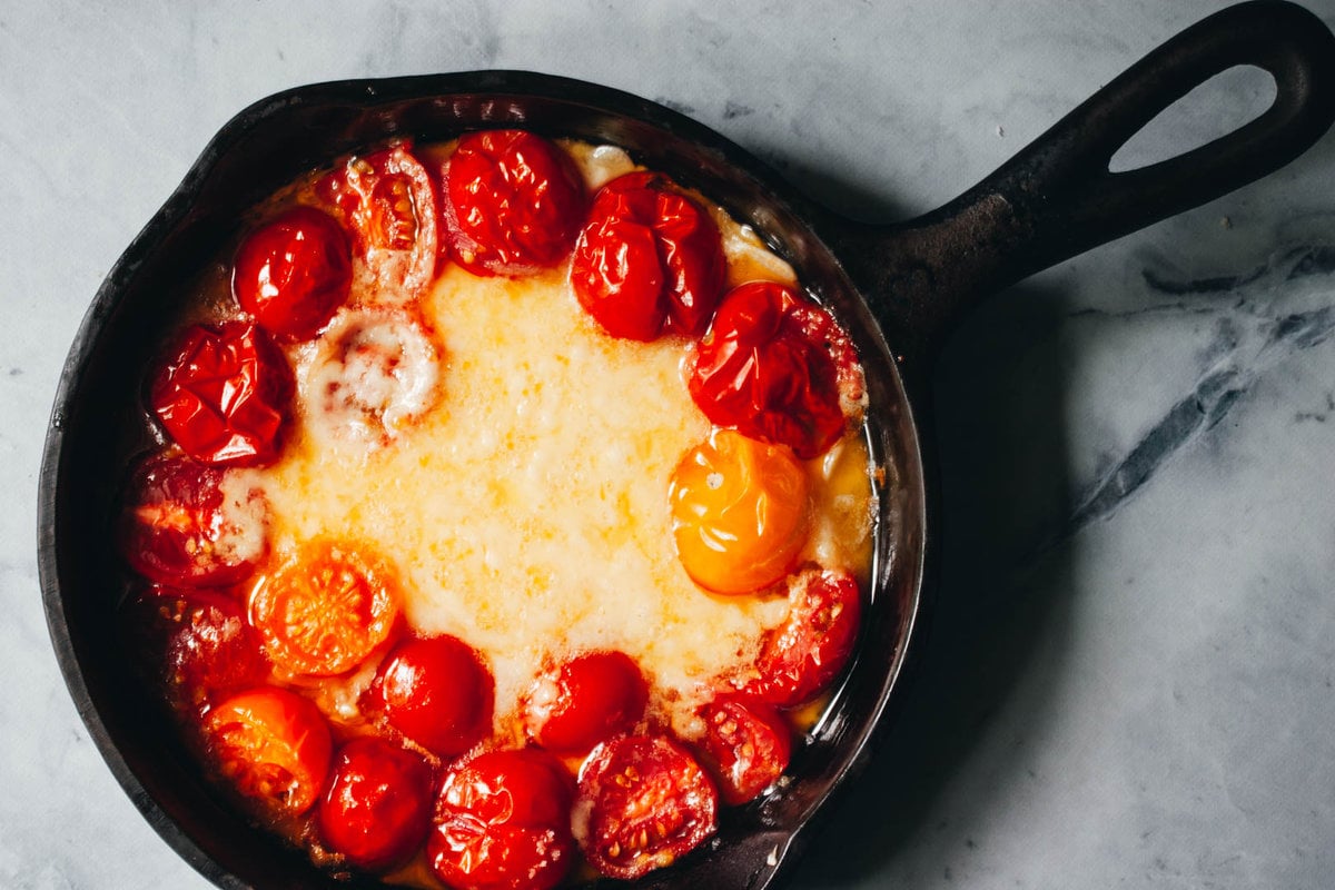roasted tomatoes and havarti cheese in a cast iron pan