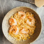 Sweet Corn Pasta with Shrimp in a bowl with parmesan cheese on the side