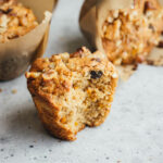 carrot muffin with a large bite out of it with muffins in the background