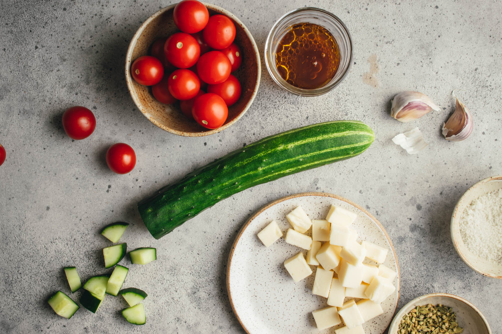 ingredients for Italian salad in different size bowls on a gray background