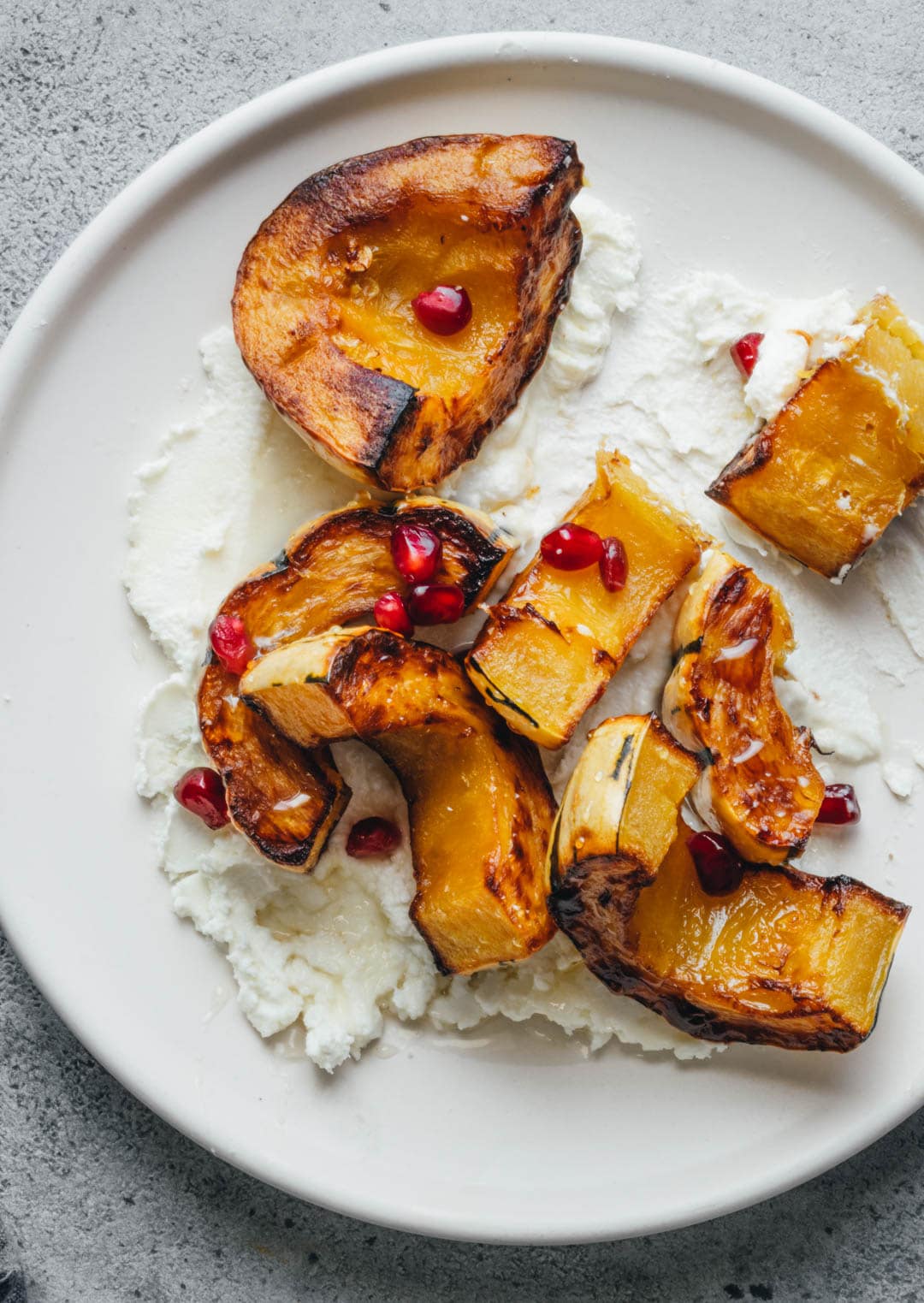 Roasted Delicata Squash on top of goat cheese and sprinkled with pomegranate arils and drizzled with honey