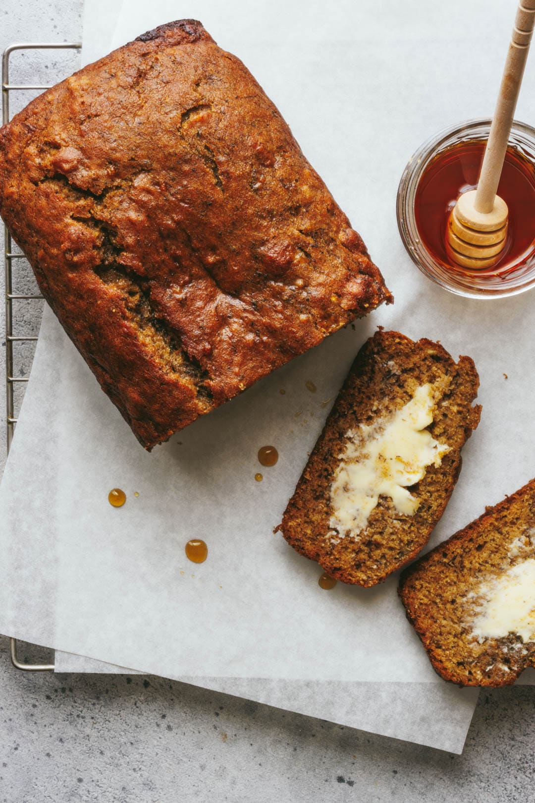 2 slices of banana bread cut from the loaf with maple syrup on the side