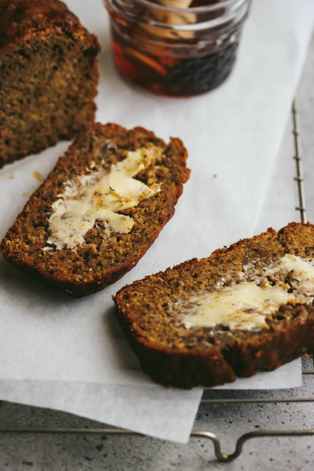 2 slices of cinnamon maple banana bread cut from the loaf with maple syrup on the side