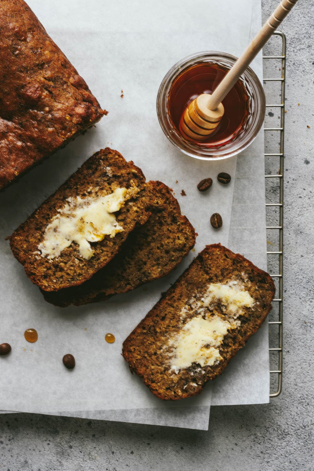 3 slices of cinnamon maple banana bread cut from the loaf with maple syrup on the side