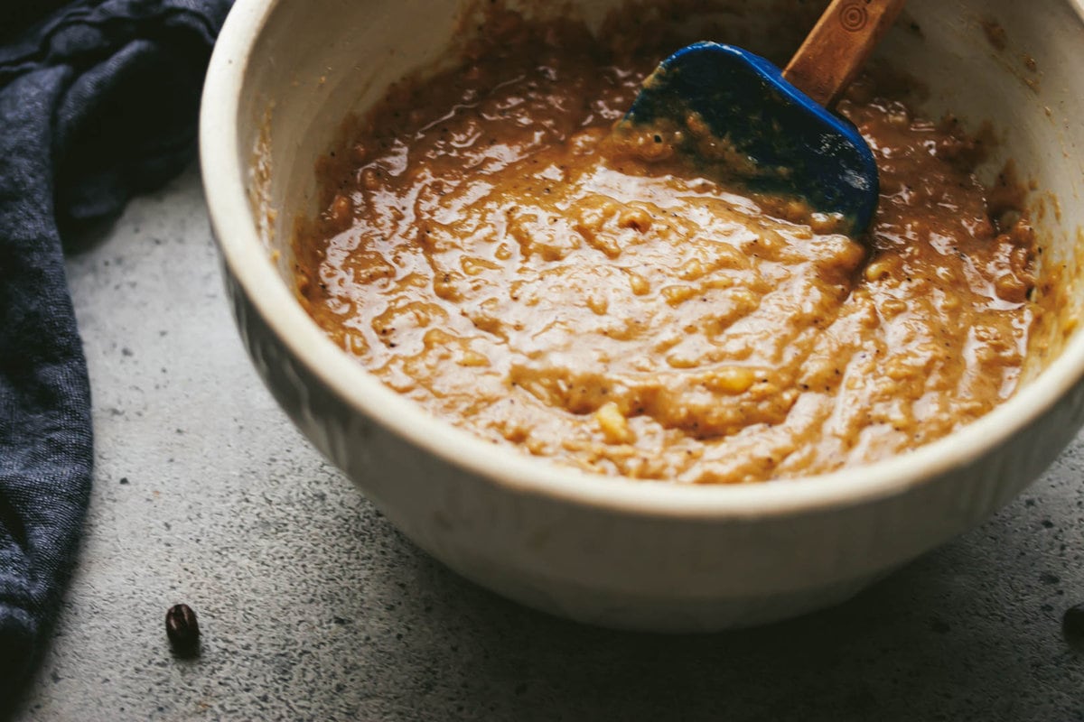banana bread batter in a large bowl with a rubber spatula