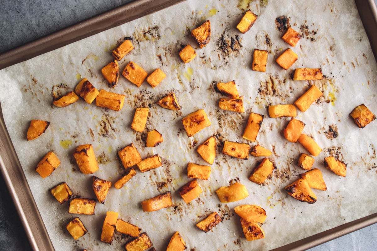 Deeply browned roasted butternut squash on a baking sheet