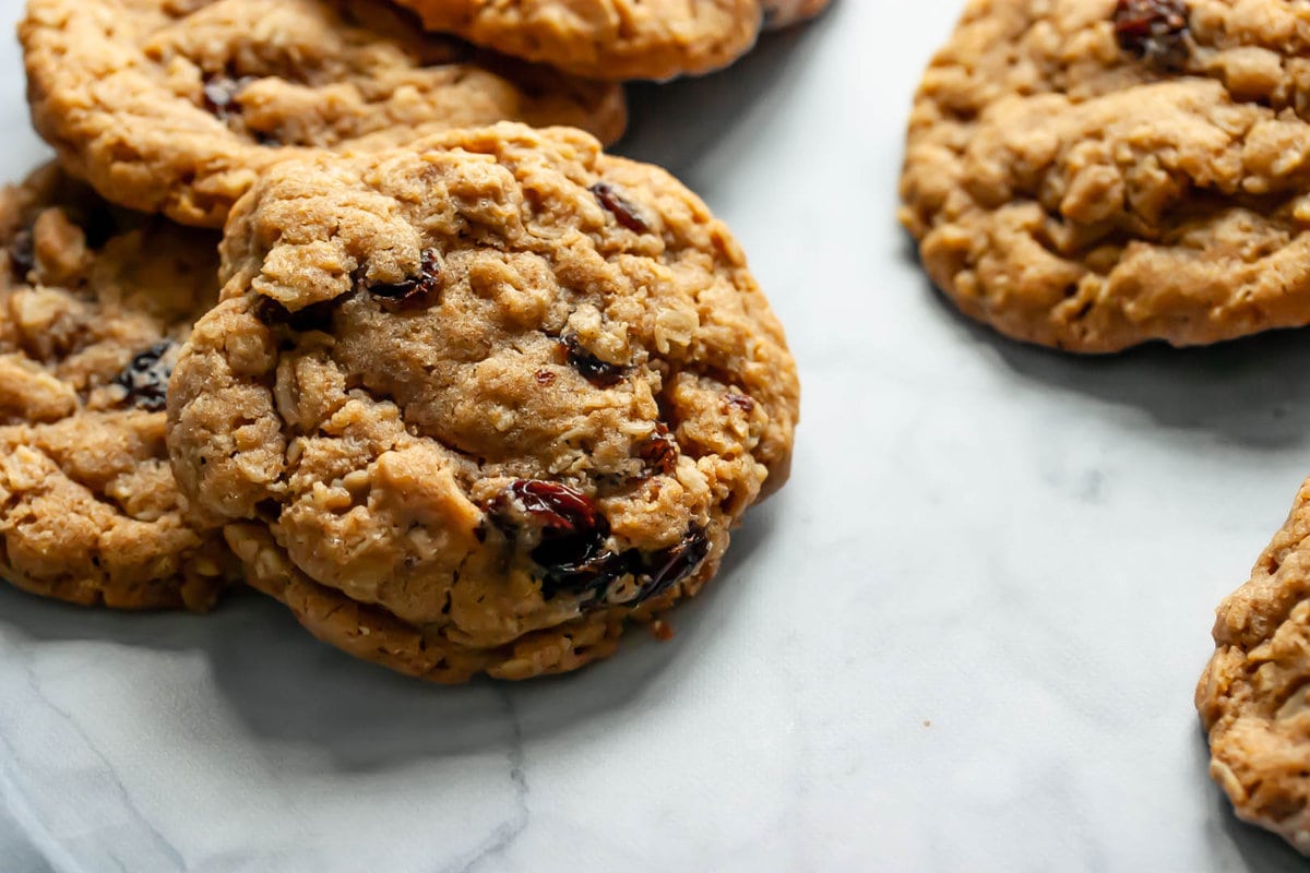 old-fashioned oatmeal raisin cookies stacked on top of each other on a marble background