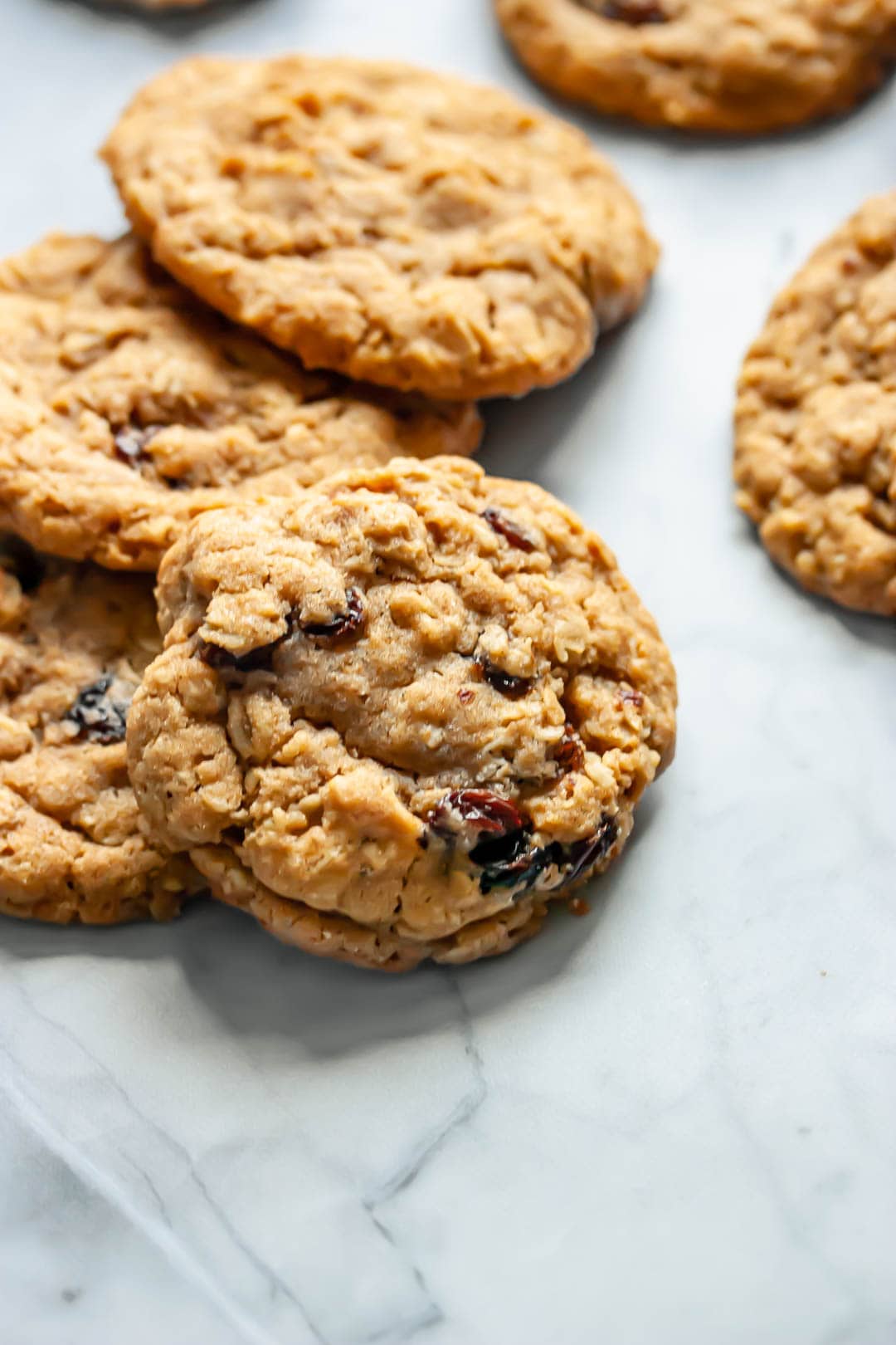 old-fashioned oatmeal raisin cookies stacked on top of each other on a marble background