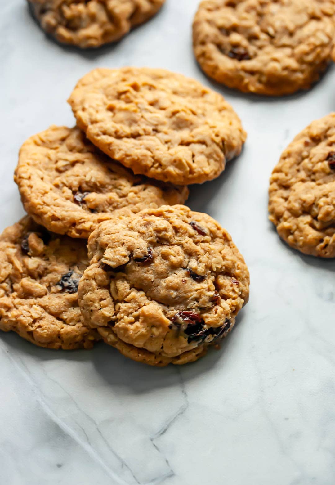 old-fashioned oatmeal raisin cookies stacked on top of each other on a marble background