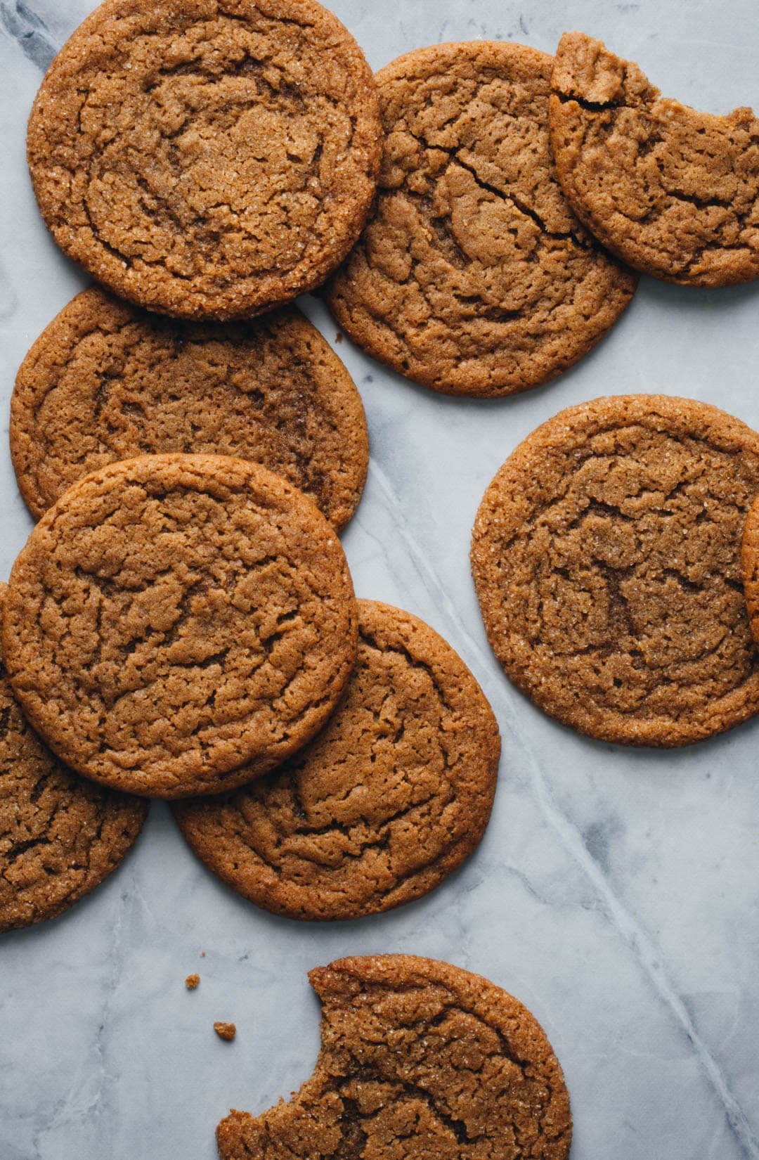 thin and chewy ginger molasses cookies stacked on top of one another with a bite taken out of one